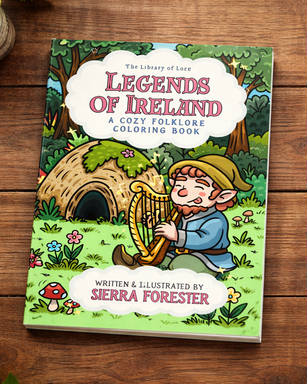 Coloring book titled 'Legends of Ireland' on a wooden surface with illustrations of an elf playing a harp.